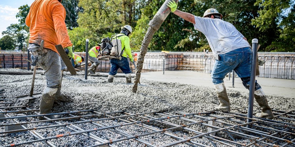 Operários concretando uma laje em uma obra pública.